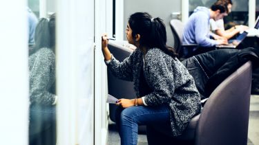 Student writing on a whiteboard in a University of Sheffield study space