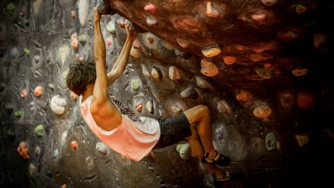 Woman boulderer climbing at an indoor wall