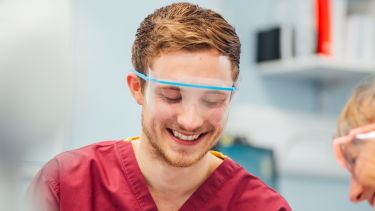 Male dental student treats patient