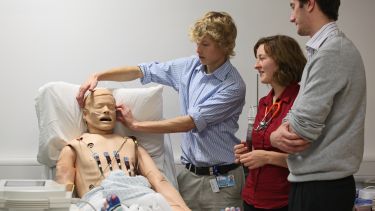 Student examines medical dummy