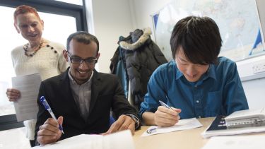 Teacher observes students work