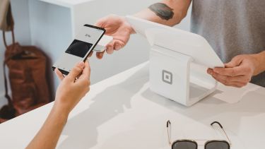 A customer paying for a purchase in a shop using the contactless option on their smartphone.