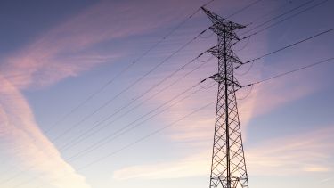 a large electricity tower in the sunset
