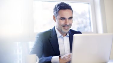 Businessman working on a laptop smiling