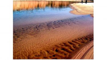 Transverse sand ripples formed on a river bed arising from an instability in the coupled flow of water and sand.