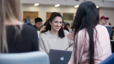 Students talking in the soft seating area in courtyard café