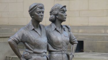 A portrait image of the Women of Steel statue