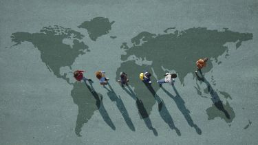 Students walking across map of the world