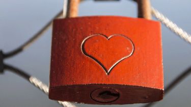 A red padlock with a heart engraved