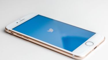A mobile phone with the Twitter logo on the screen