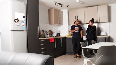 two students stood in a kitchen
