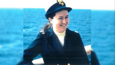 Susan on a ship, in her Navy uniform