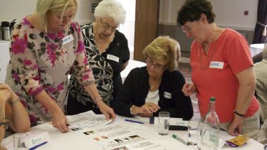 Group of elderly ladies at table looking at papers