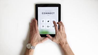 Person using iPad with social media icons on the screen