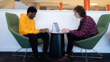 Two students working at their laptops