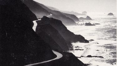 Artwork of a road winding around hills next to the sea