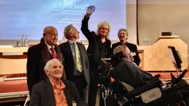 A group photo of Harry Kroto, Stephen Hawking and Brian May.