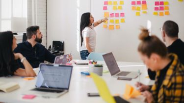 woman placing sticky notes on wall