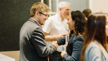 An alumnus and a student shaking hands