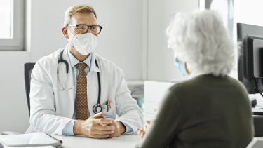 A picture of a GP chatting with a patient