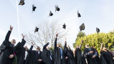 Students throwing caps into sky