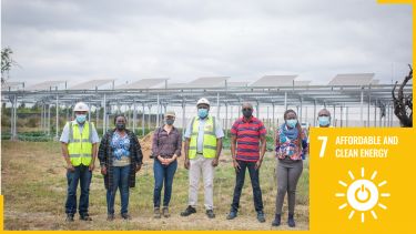 Group of people wearing safety clothing and masks in field