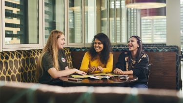 three female students sat together in the edge bar laughing