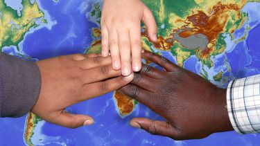 Three hands over a map of the world
