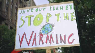 A protest sign 'Save our planet. Stop the warming'