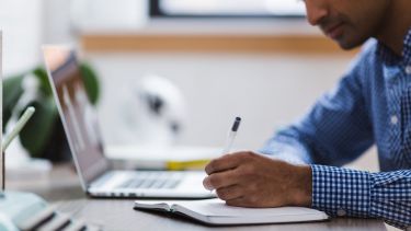 A man writing in a notebook