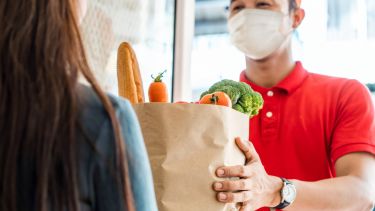 Photo of man handing bag of shopping to a woman