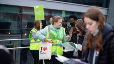 Open day volunteer helping a student outside the Students' Union
