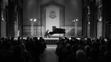 Imogen Cooper playing steinway piano on stage in firth hall with large audience