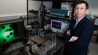 Professor Tao Wang standing next to one of the extensive device characterisation and testing facilities in the photoluminescence and electroluminescence laboratories at the University of Sheffield