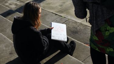 A Landscape Architecture student shows her sketchbook to a tutor