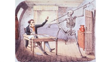 A skeleton raises a spear to smite the shocked writer sat at table