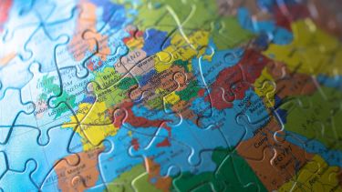 A close up photograph of a jigsaw puzzle depicting the globe