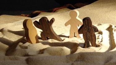 An image of figures in sand