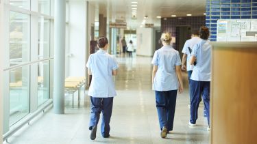Three nurses walking down a hospital corridor