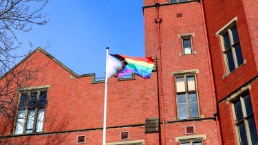 A photograph of the LGBT+ flag flying outside Firth Court