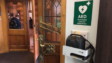 A close-up of the automated external defibrillator in Firth Court.