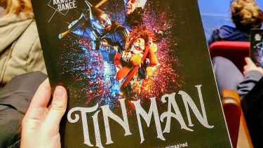 A hand holding a programme for the Tin Man panto