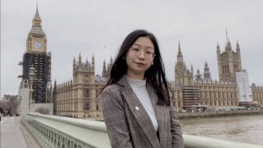A photograph of LLM student QiuYi in London standing next to the river Thames