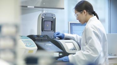 Scientist conducting the process of Polymerase chain reaction (PCR) to amplify DNA by using a thermocycler to create samples - stock photo