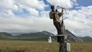 A member of the research team checking tundra monitoring instruments in Ivotuk, Alaska