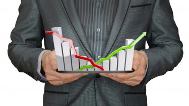 An image of a man wearing a suit holding a bar chat showing growth and decline.