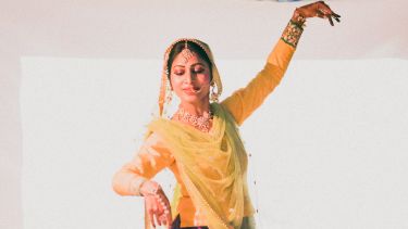A woman performing a traditional Indian dance