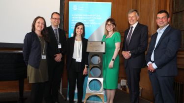 Photo of VIP guests next to plaque at the Royce Discovery Centre opening