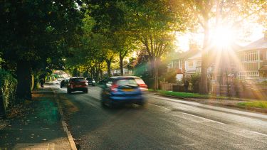 Cars on a tree-lined suburban road in the UK