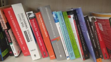 Image of statistics textbooks on a shelf
